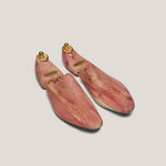 Pair of wooden shoe trees on a light beige background