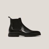 Black Chelsea boot on a light gray background
