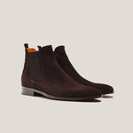 Pair of brown suede Chelsea boots on a light gray background