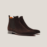 Pair of brown suede Chelsea boots on a light gray background