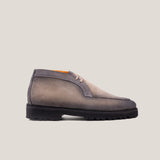 A taupe grey suede derby chukka boot with a lace-up closure and a round toe shape.