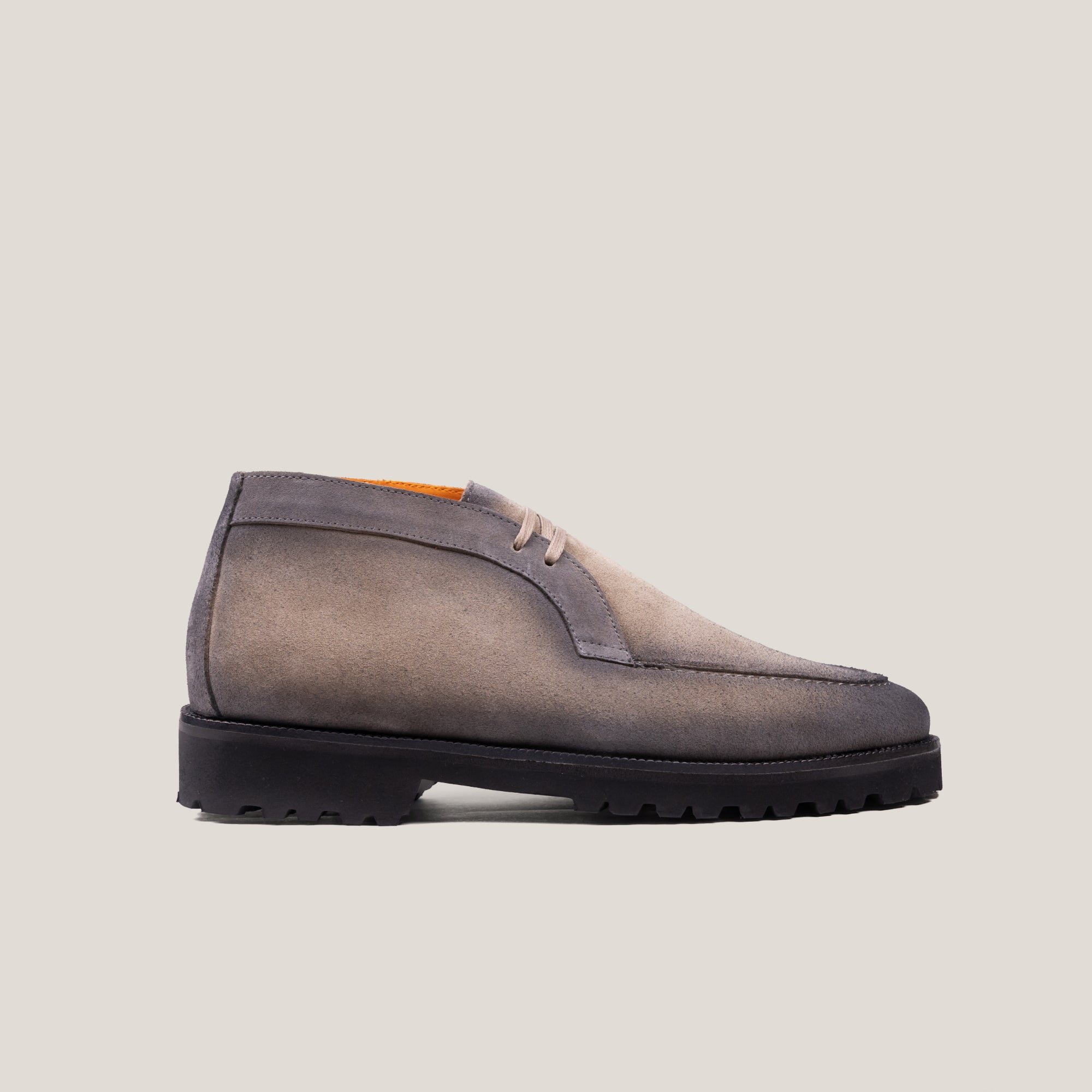 A taupe grey suede derby chukka boot with a lace-up closure and a round toe shape.
