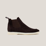 A dark brown suede Chelsea boot with a white sole.