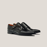 A pair of black leather double monk shoes with silver buckles.