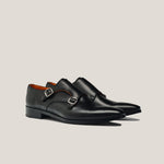 A pair of black leather double monk shoes with silver buckles.
