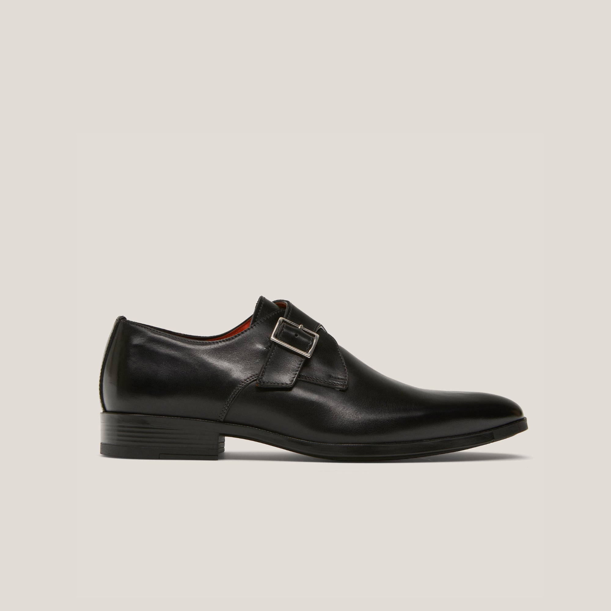 A black leather single monk strap shoe with a square buckle and a low heel.